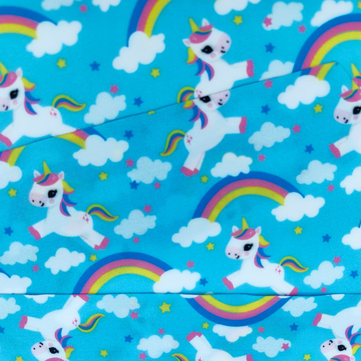 Close-up of unicorn and rainbow fabric strap for kids swim goggles