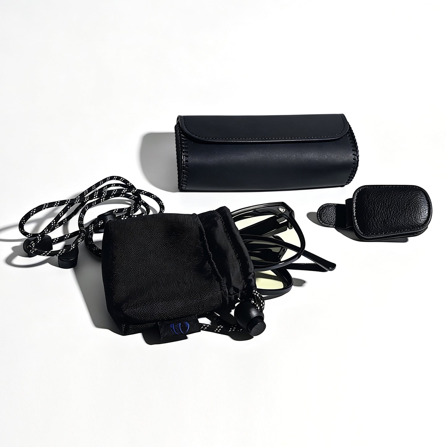 Folded glossy black fit-over night driving glasses in microfiber pouch, with visor clip and protective storage box.