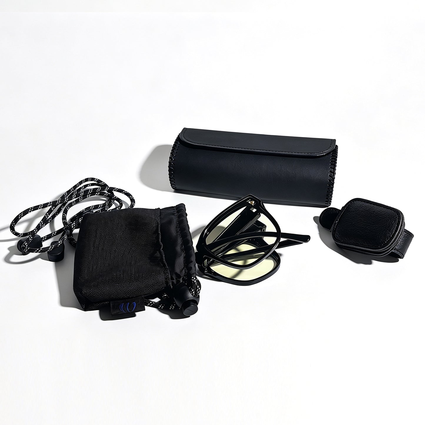 Folded glossy black fit-over night driving glasses with visor clip, protective storage box and microfiber pouch