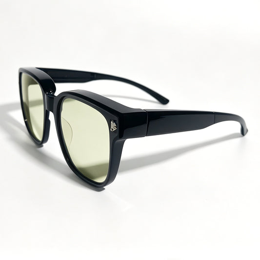 Glossy black fit-over night driving glasses with yellow-tinted lenses, shown from a front three-quarter angle.