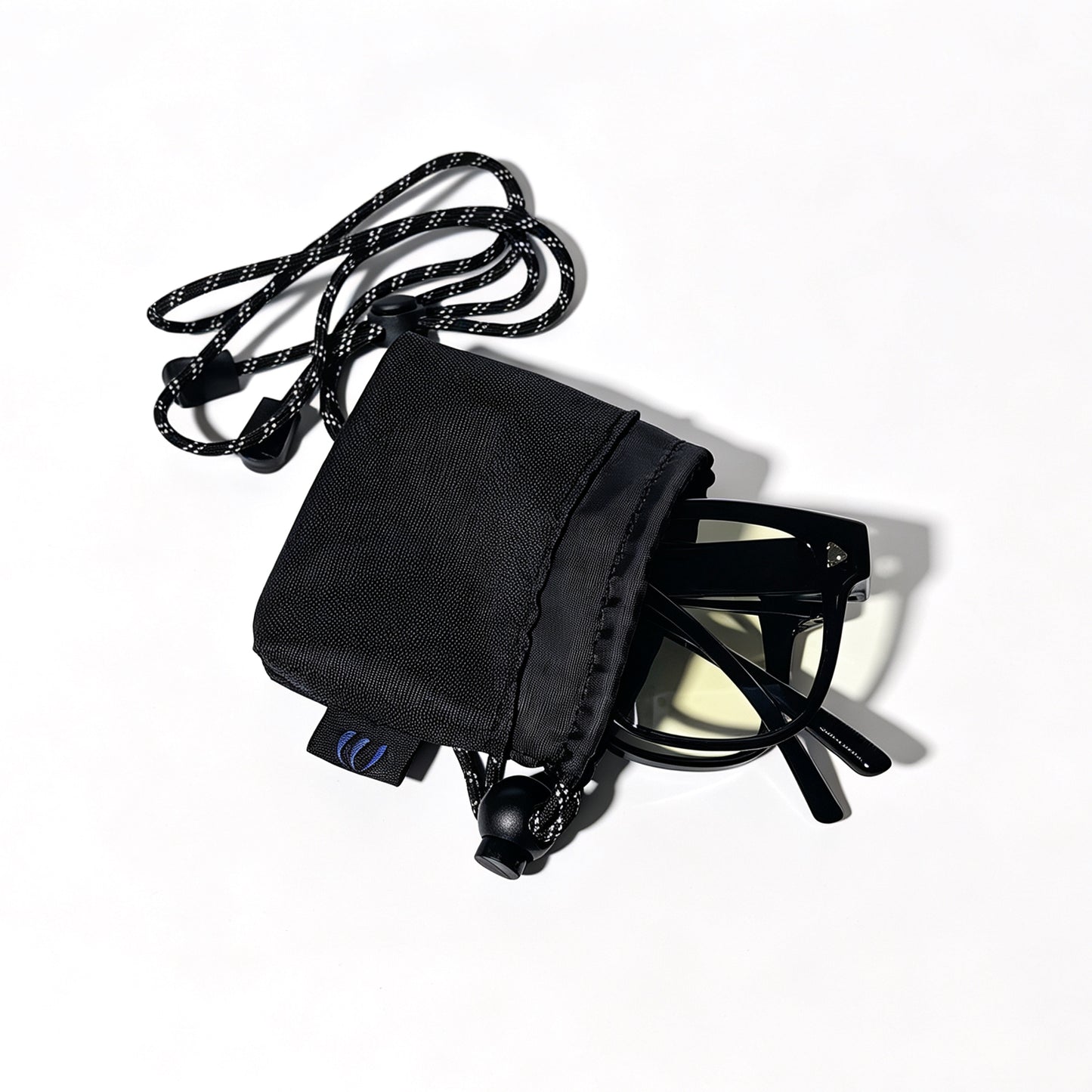 Glossy black fit-over night driving glasses partially stored in a black drawstring protective pouch.