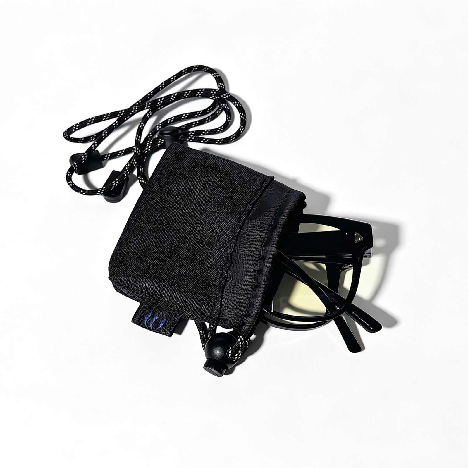 Glossy black fit-over night driving glasses partially stored in a black drawstring protective pouch.