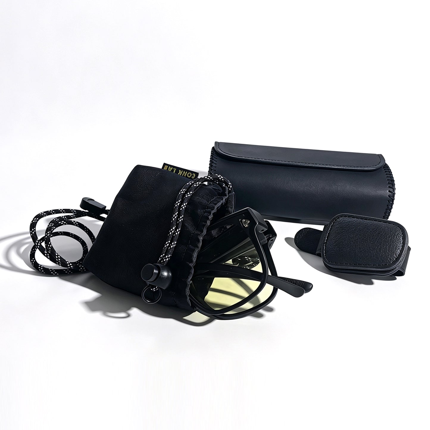 Folded matte black fit-over night driving glasses with visor clip, protective storage box and microfiber pouch