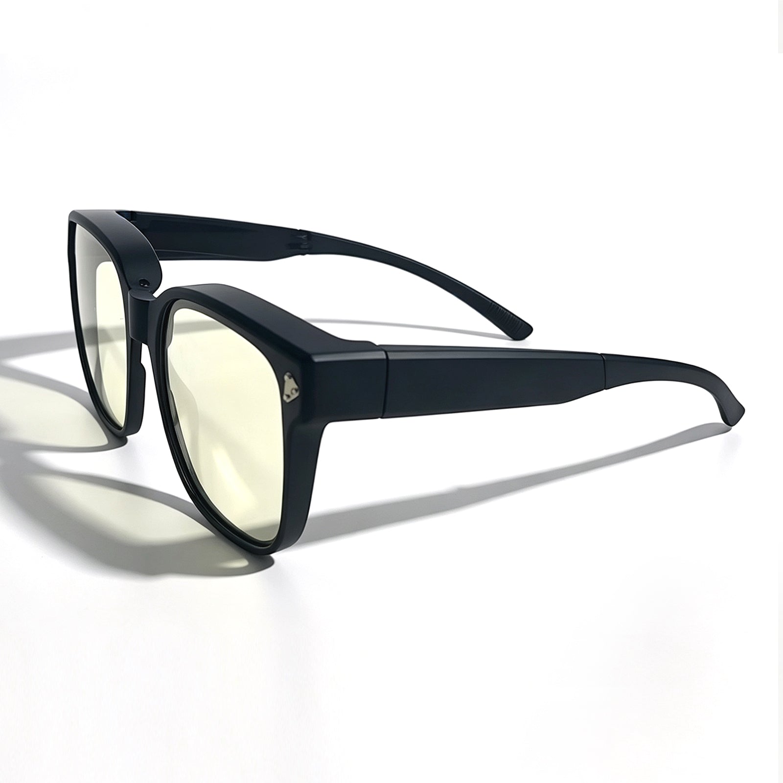 Side view of matte black fit-over night driving glasses with light yellow lenses and curved temple tips.