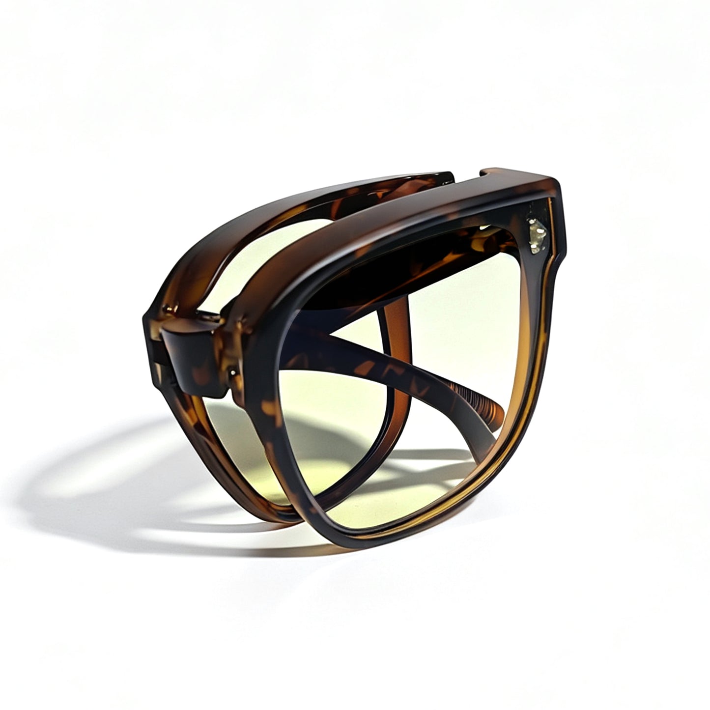 Tortoiseshell fit-over night driving glasses with yellow-tinted lenses, fully folded to show the compact foldable temple design.