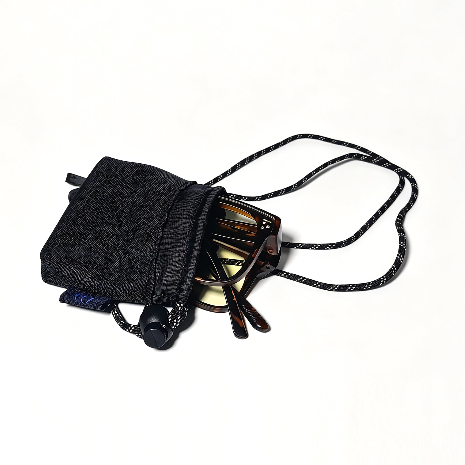 Tortoiseshell fit-over night driving glasses partially stored in a black drawstring protective pouch.